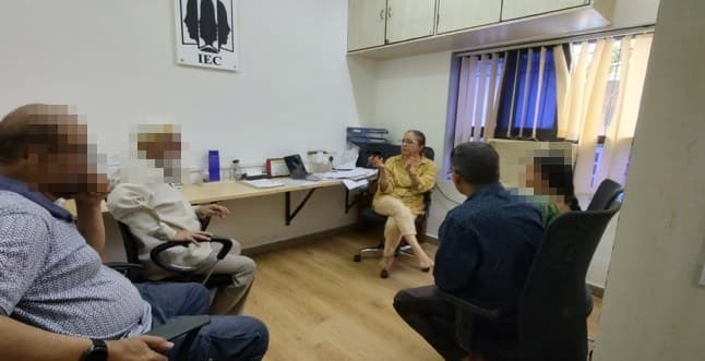 A group session under way in a consulting room at the IEC office, the attendees' faces redacted